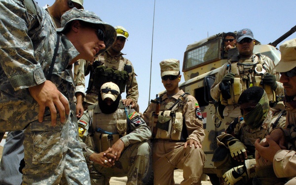 U.S. and Iraqi soldiers gather around for an after-action review.