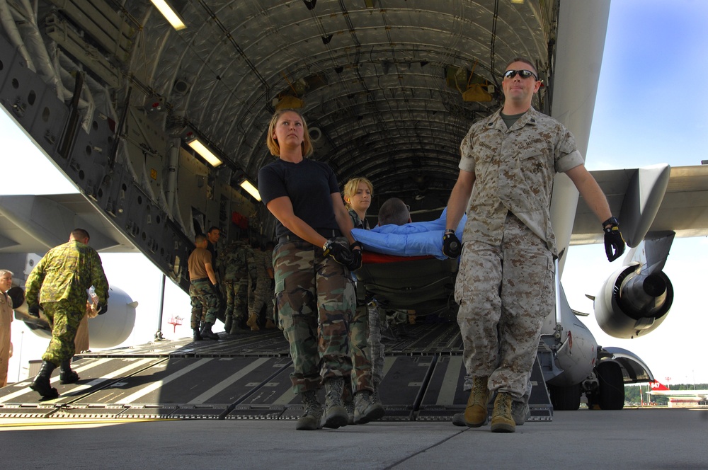 Wounded military members are carried from an aeromedical evacuation flight.