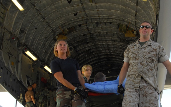 Wounded military members are carried from an aeromedical evacuation flight.