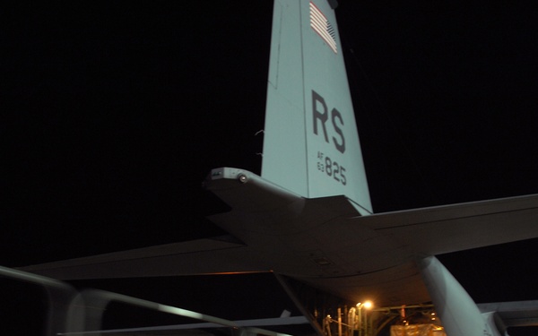 U.S. Air Force airmen load cargo onto a C-130 Hercules aircraft.