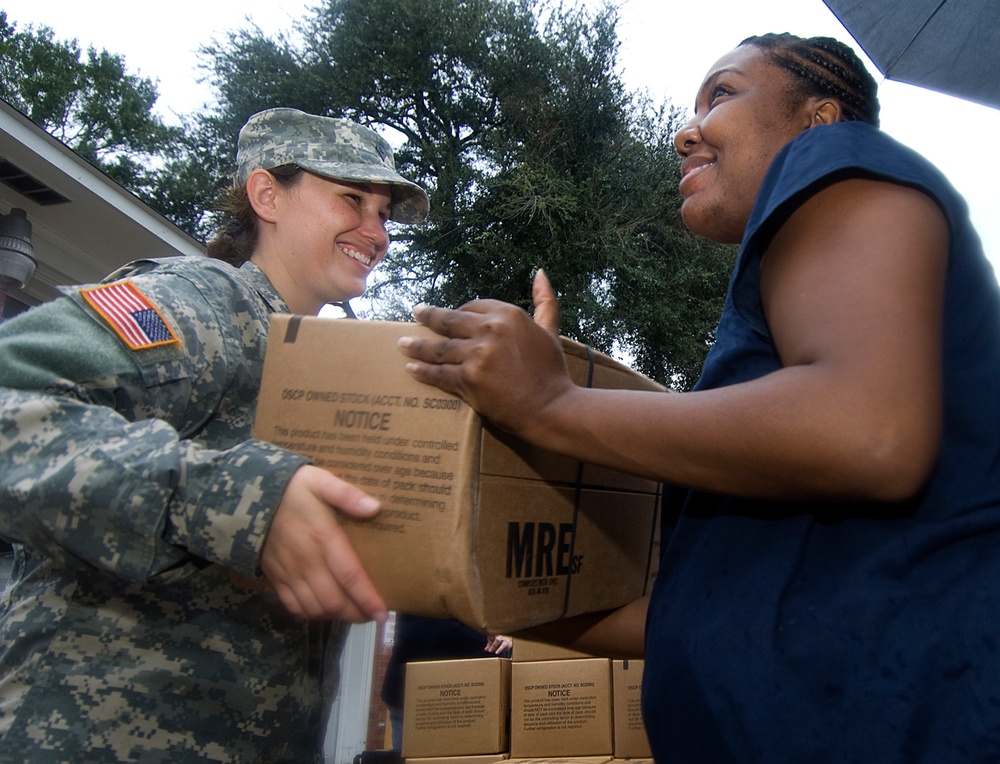 Spc. Jacquelyn Smith hands out boxes of meals, ready-to- eat.