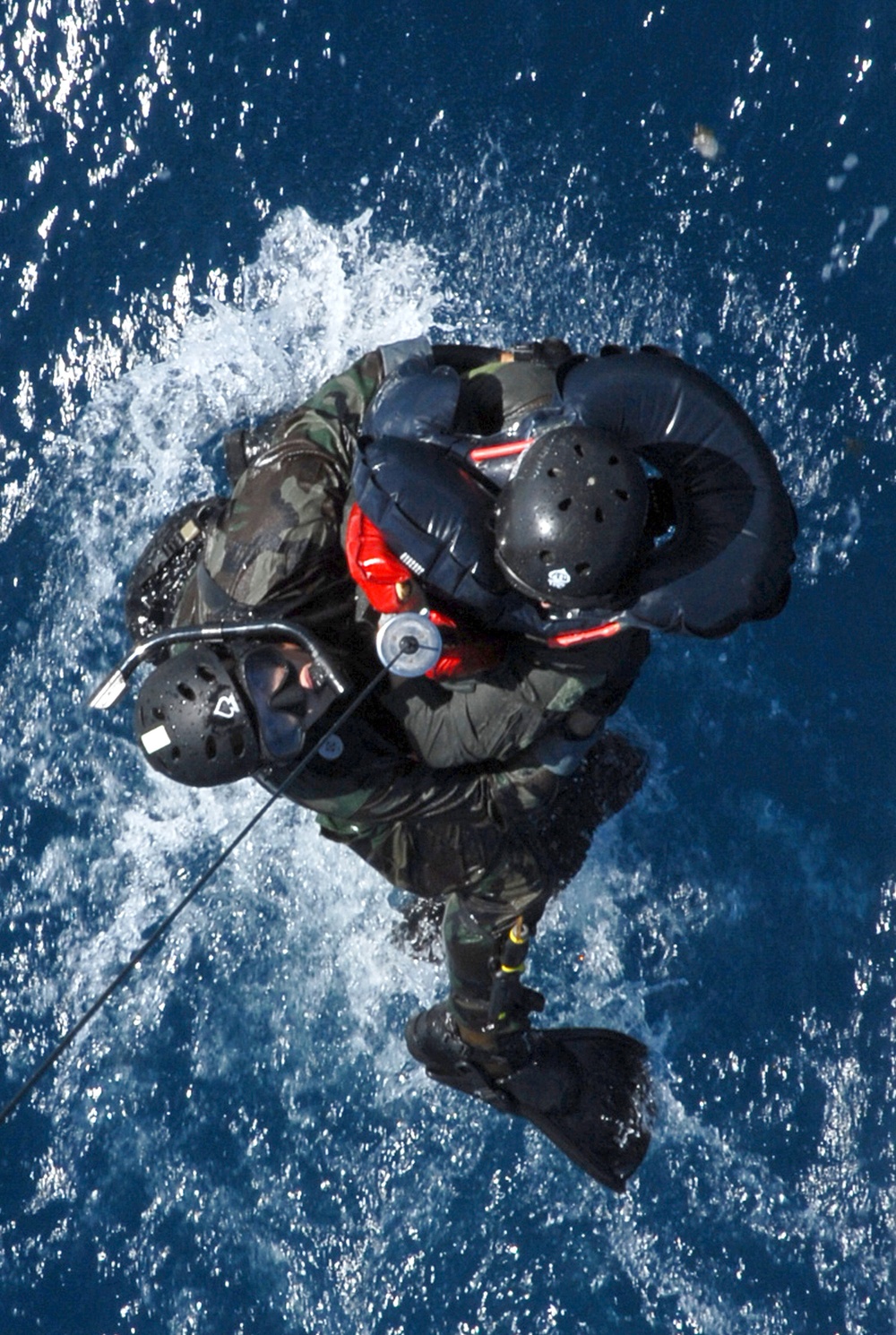 Senior Airman Oliver Smith and a downed F-15 pilot are hoisted onto an HH-60 Pave Hawk helicopter.