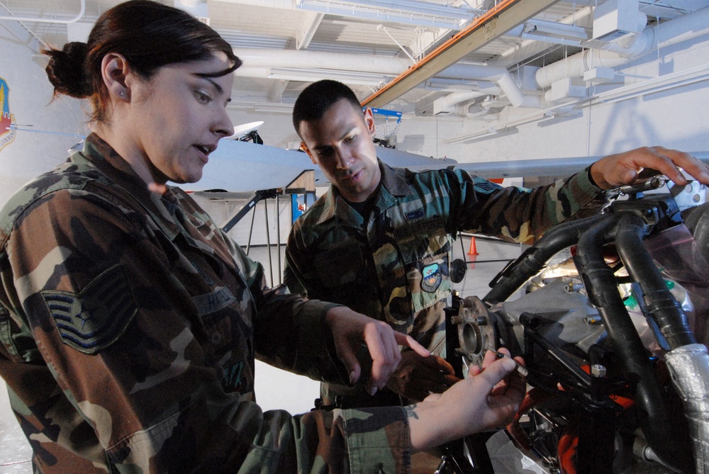 Tech. Sgt. Rebecca Hatfield shows the components of an MQ-1 Predator unmanned aerial vehicle engine.