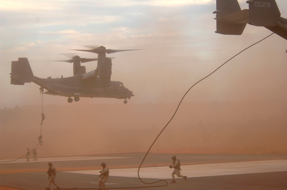 Special forces members disembark from CV-22 Osprey aircraft.