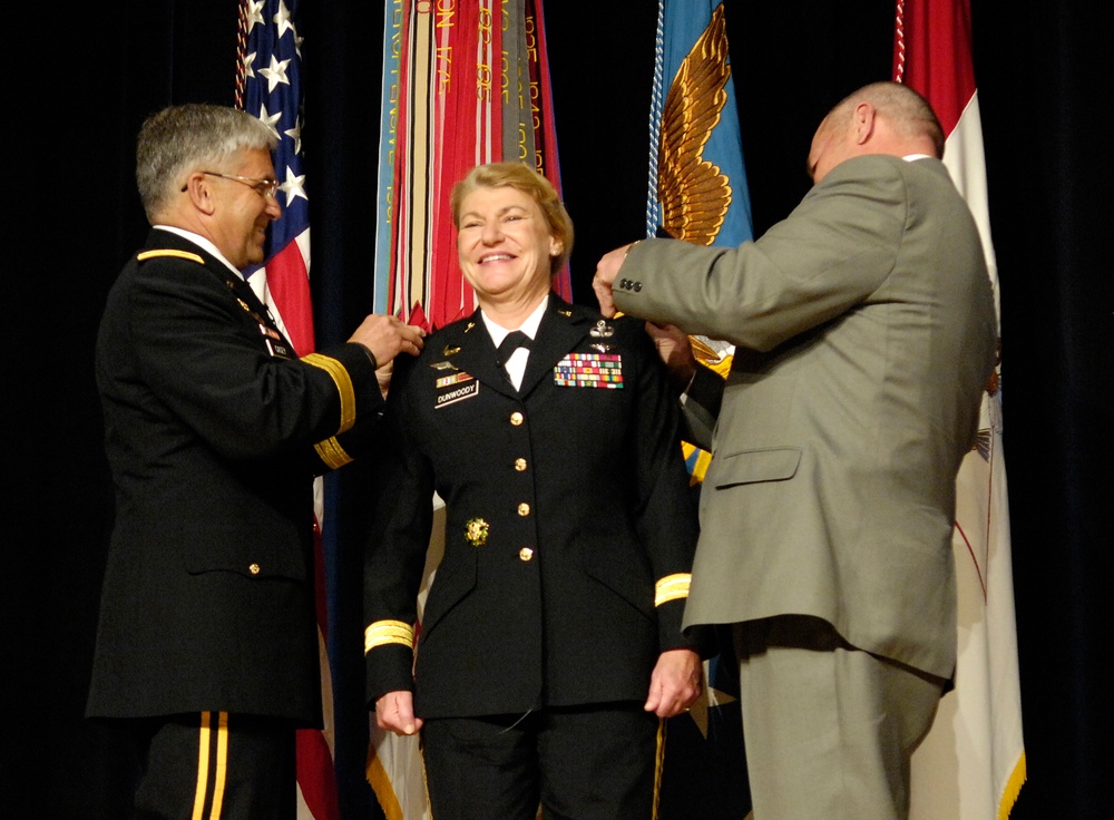Lt. Gen. Ann E. Dunwoody smiles as Gen. Casey and her husband pin the rank of general on her.