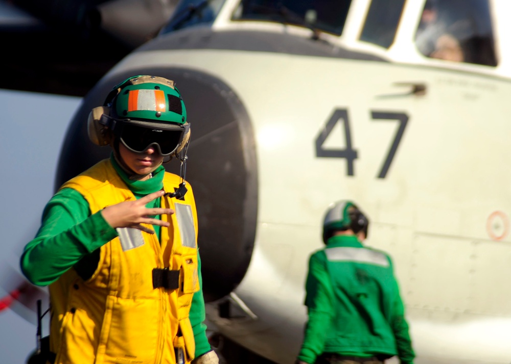 Petty Officer 3rd Class Nancy Germann signals to a shooter.