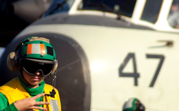 Petty Officer 3rd Class Nancy Germann signals to a shooter.