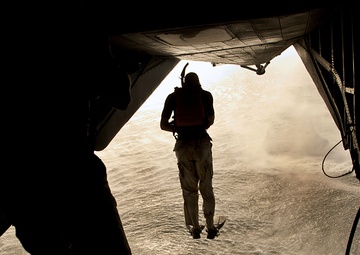 U.S. Air Force pararescuemen jump from a CH-53 Sea Stallion helicopter.