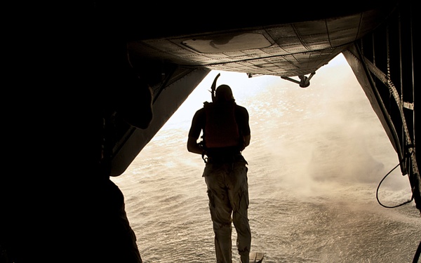 U.S. Air Force pararescuemen jump from a CH-53 Sea Stallion helicopter.