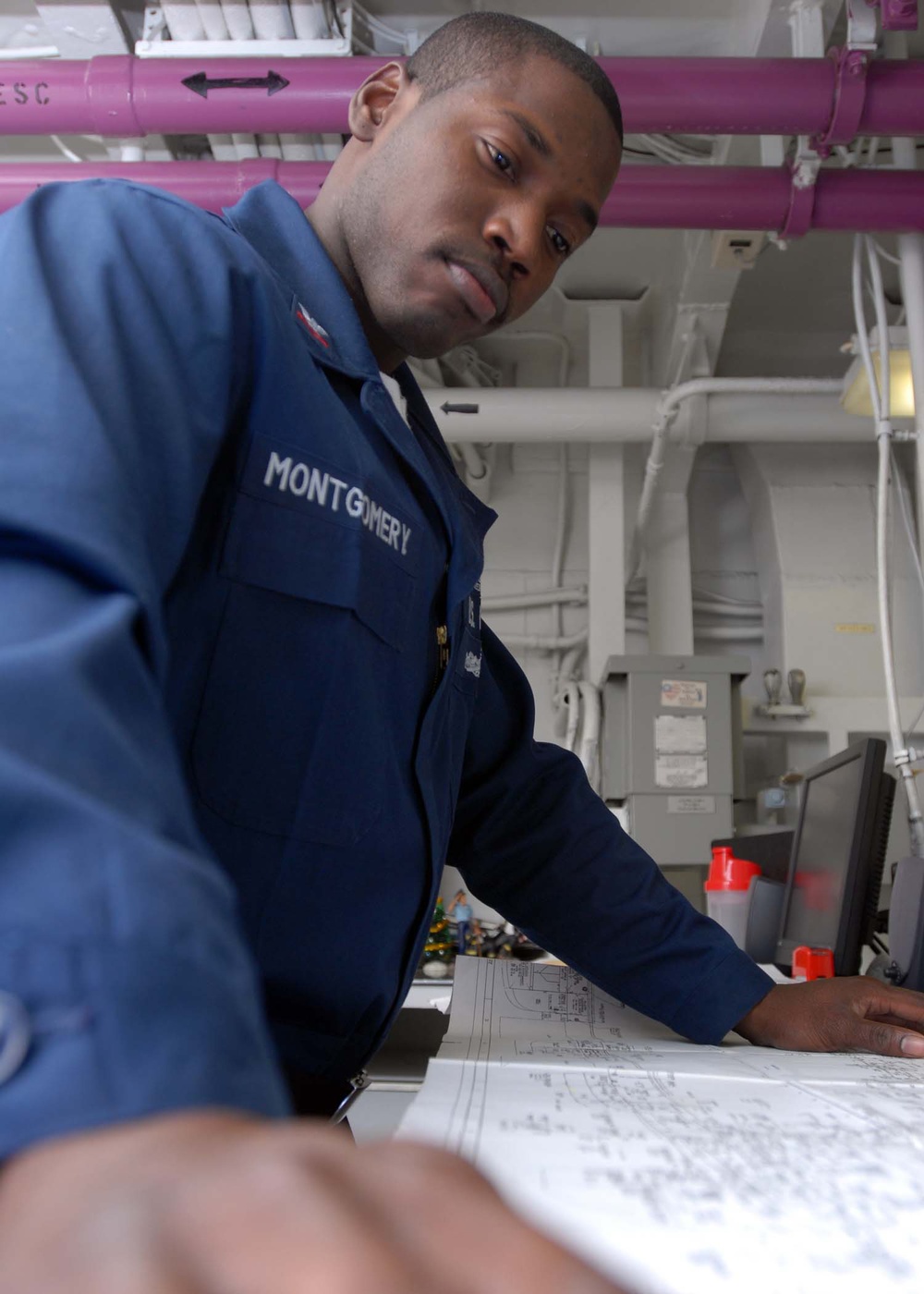 Petty Officer 2nd Class Otto Montgomery reviews blueprints.