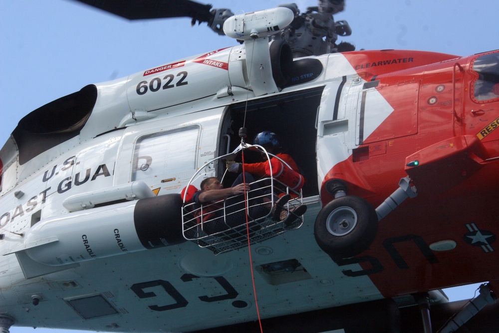 U.S. Coast Guardsmen lift Nick Schuyler from an overturned vessel.