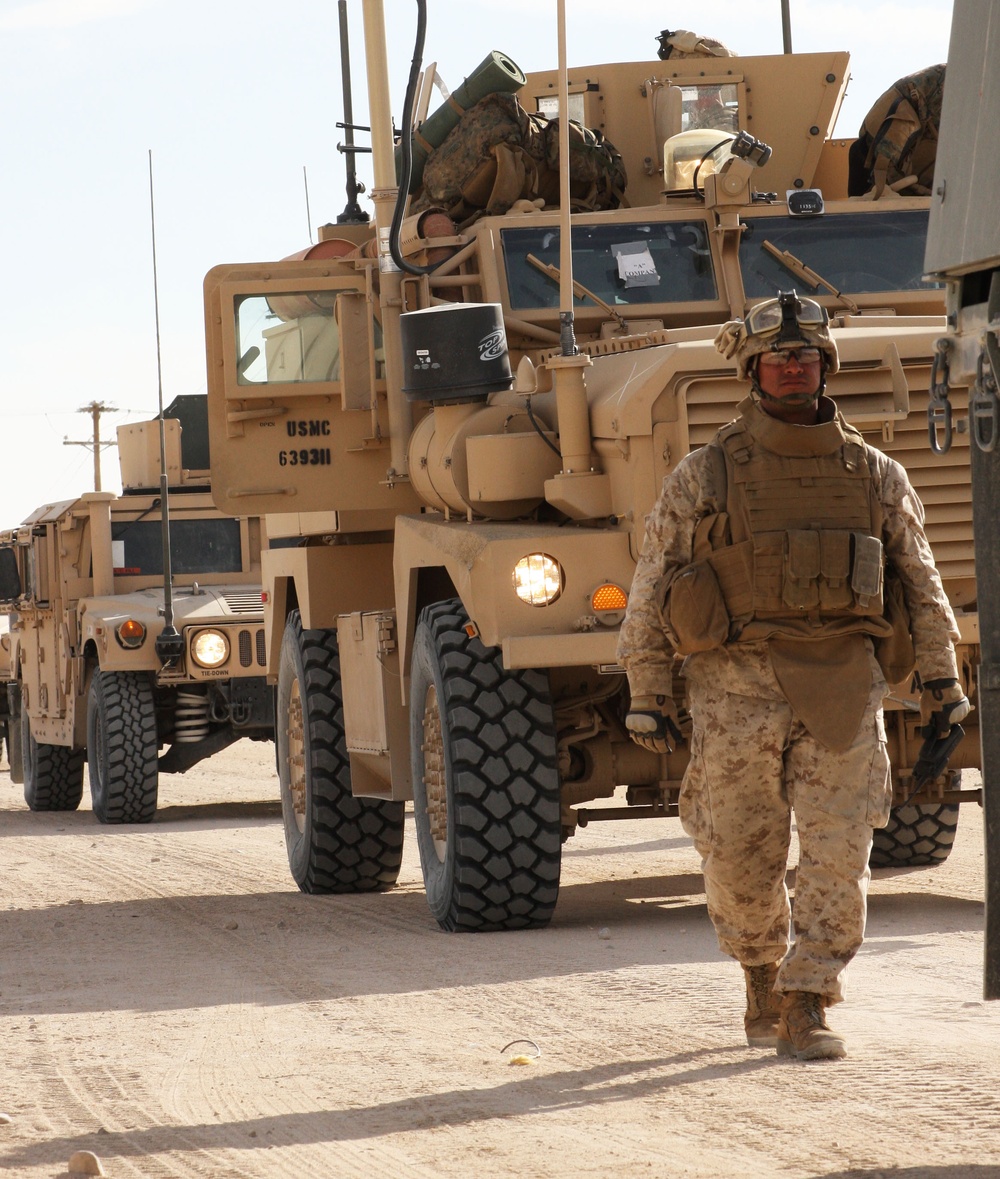 A U.S. Marine guides a convoy returning from field training.