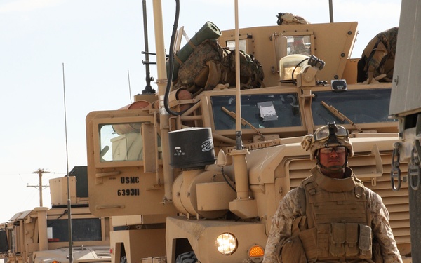 A U.S. Marine guides a convoy returning from field training.