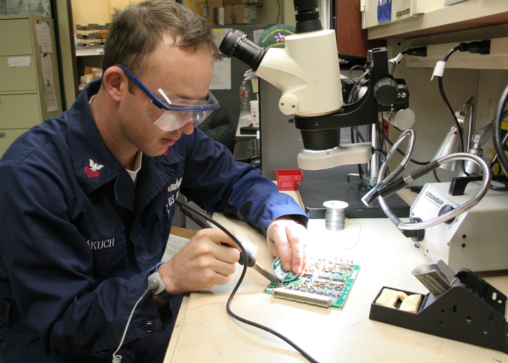 Petty Officer 1st Class Phillip Makuch conducts a component replacement.