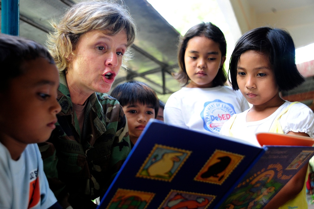 Chief Petty Officer Hope Knauss reads to school children.
