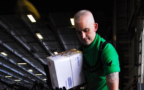 Petty Officer 2nd Class Damion Kelley sorts mail.