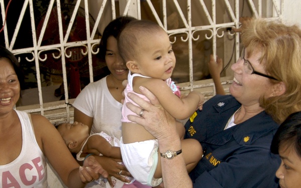 Cmdr. Debra Lowe holds a patient.
