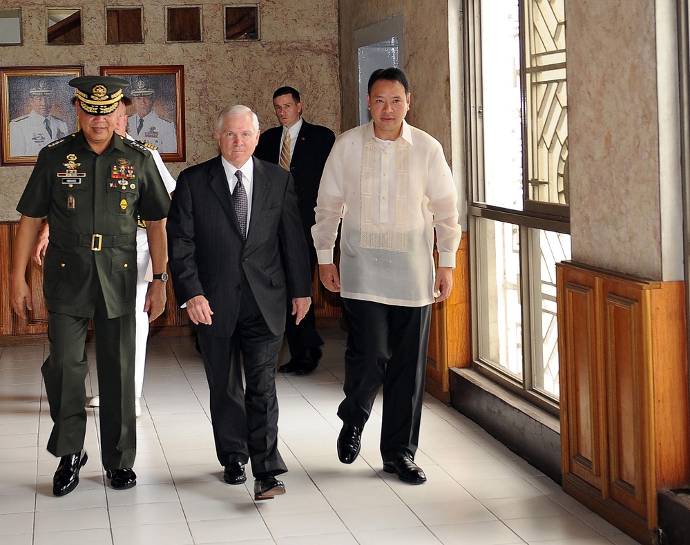 Secretary Gates and Philippine Secretary of National Defense Gilberto Teodoro Jr. walk through the headquarters building.