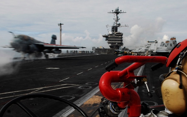 Petty Officer 3rd Class Justin Dodge mans a P-25 fire truck.