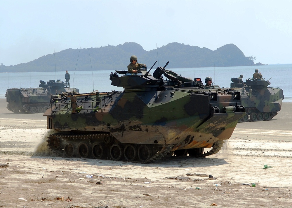 Amphibious assault vehicles transport U.S. Marines and Malaysian soldiers along Resang Beach.