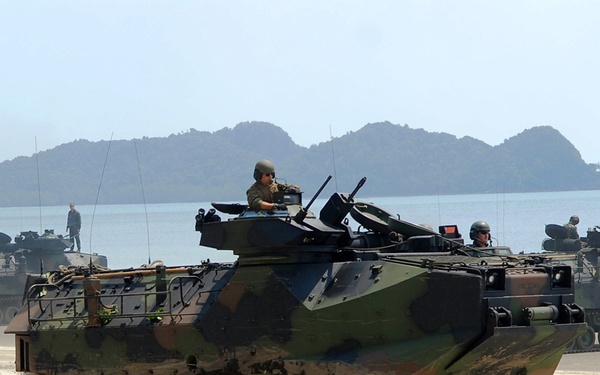 Amphibious assault vehicles transport U.S. Marines and Malaysian soldiers along Resang Beach.