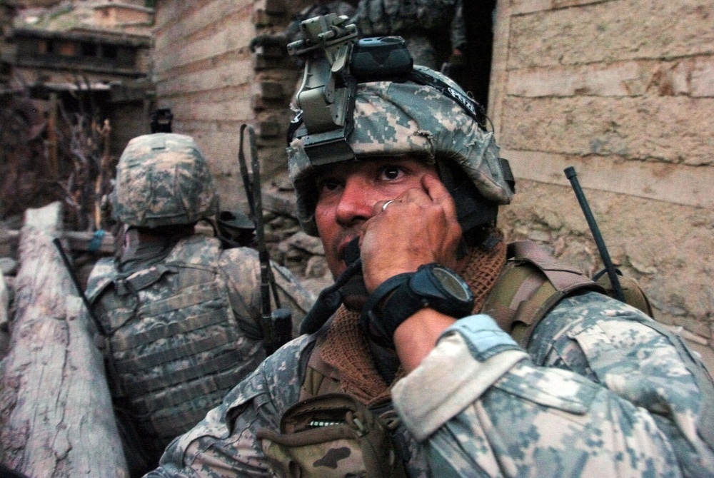 A U.S. Army soldier calls for an airstrike on the hills surrounding Barge Matal.