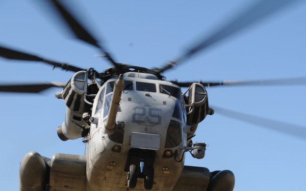 A U.S. Marine Corps MH-53E Sea Stallion helicopter prepares to lift an M777 155mm lightweight howitzer.