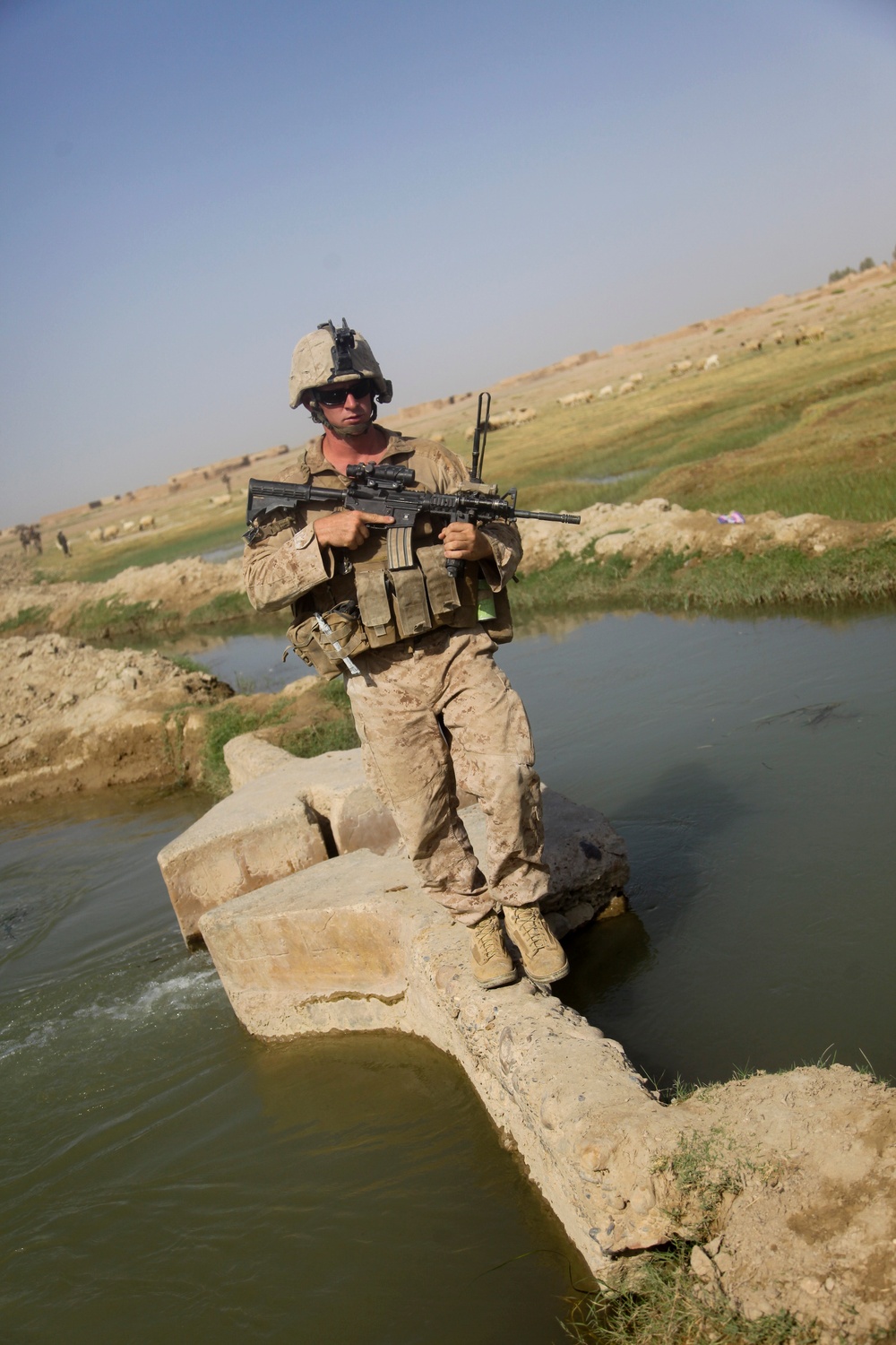 Sgt. Brian Kightlinger crosses a bridge over a canal.