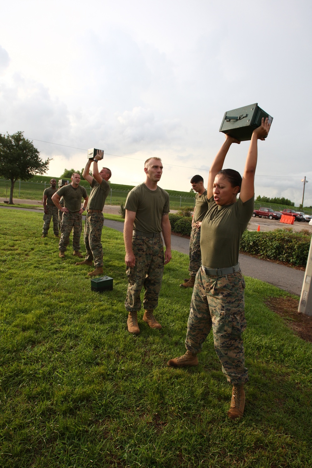U.S. Marines lift ammo cans over their heads during a combat fitness test.
