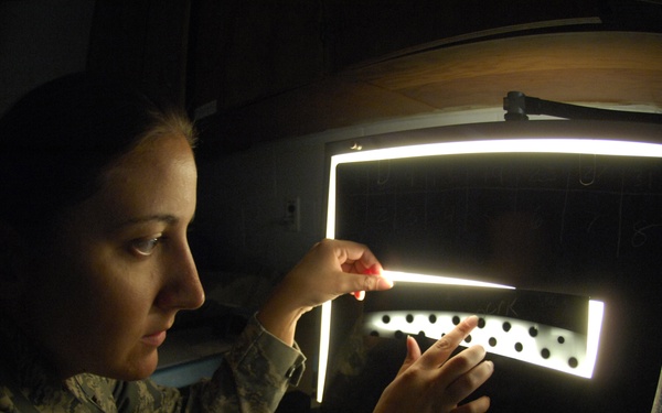 Staff Sgt. Nadine Muro examines an X-ray film strip of B-52 Stratofortress aircraft parts.