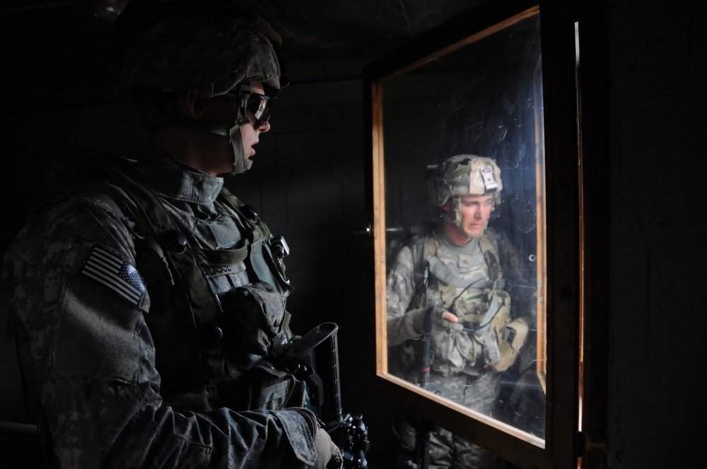 Pvt. Joseph Bosse and Sgt. Michael Tardie look out through a window.
