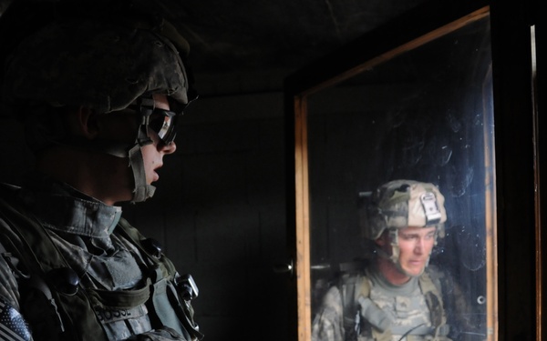Pvt. Joseph Bosse and Sgt. Michael Tardie look out through a window.