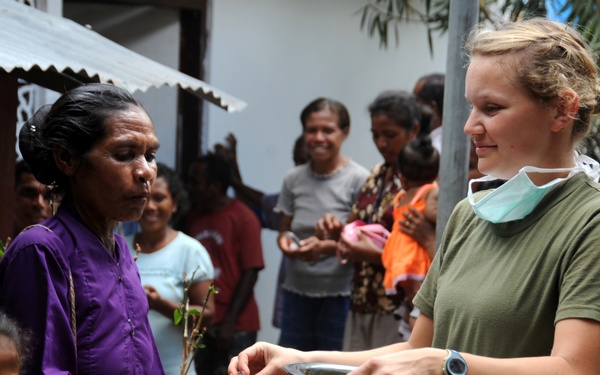 Petty Officer 2nd Class Rachel Arndt hands out toothpaste at a clinic.