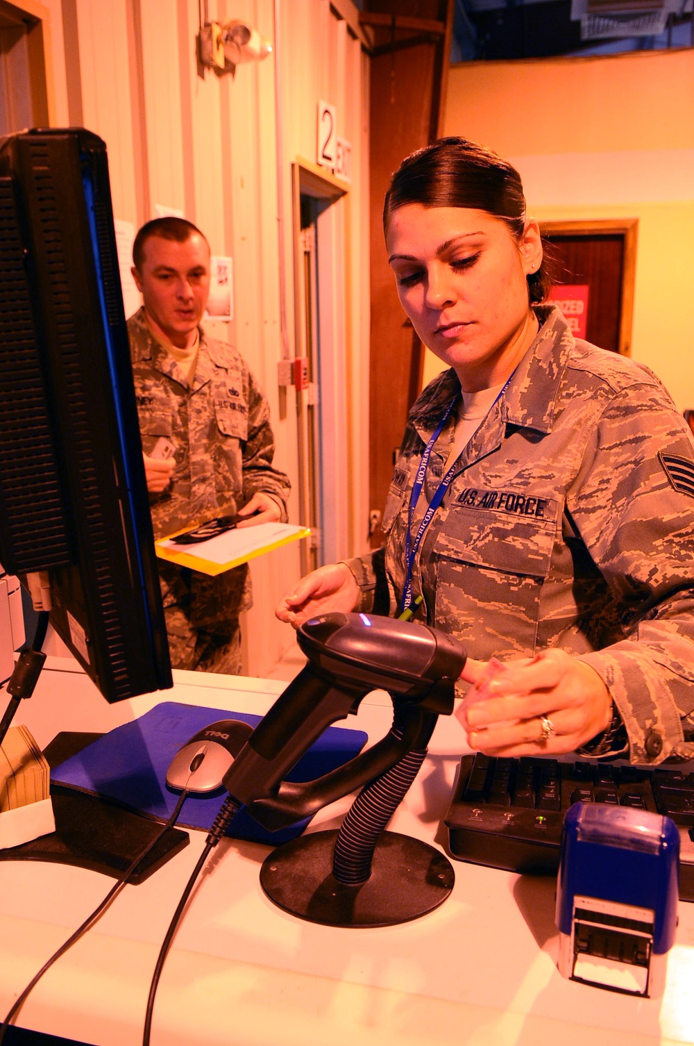 Staff Sgt. Jessica Calloway scans an airman’s identification card.