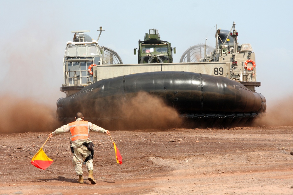 A U.S. service member directs a landing craft, air cushion.