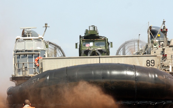 A U.S. service member directs a landing craft, air cushion.