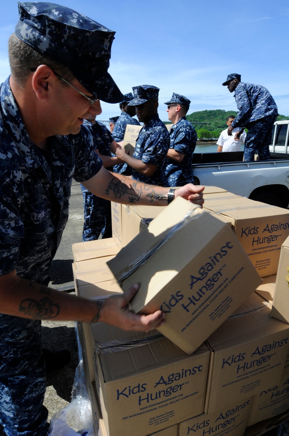 Petty Officer 2nd Class Howard Leroy helps fellow sailors load donations into vehicles in Rodman-Balboa, Panama.
