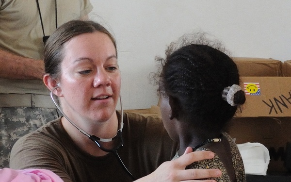 Lt. j.g. Julie Cole examines a child during a medical civic action program.
