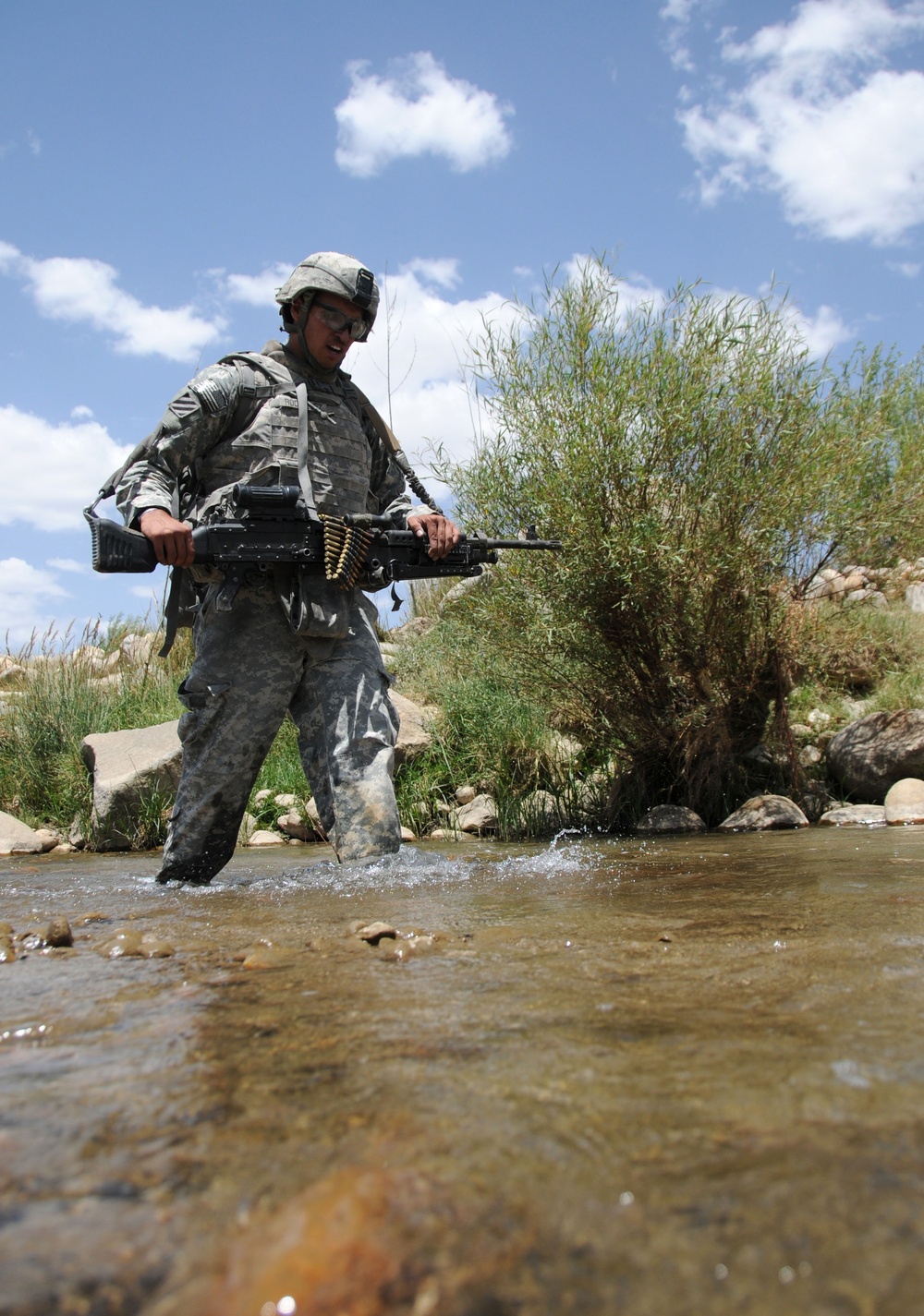 Spc. Brandon Rodriguez crosses a stream while patrolling the area surrounding Forward Operating Base Baylough.