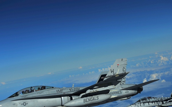 Two U.S. Marine Corps F/A-18 Hornet aircraft fly a mission over the Pacific Ocean.