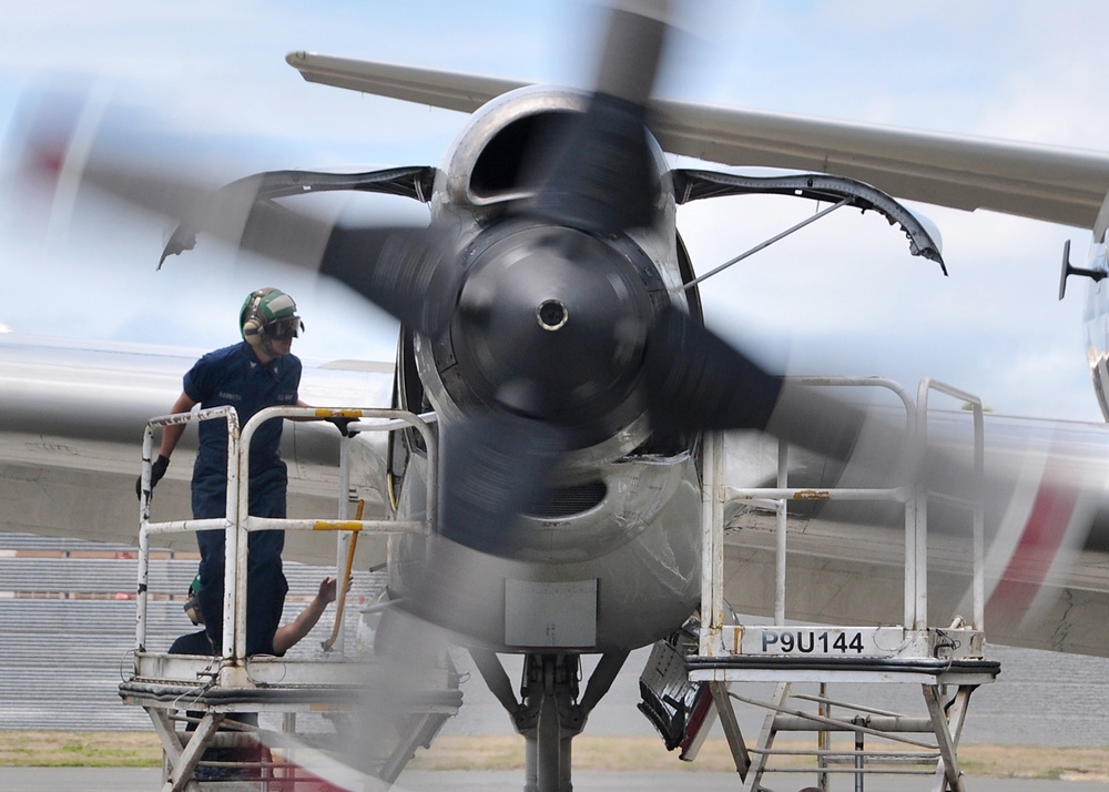 Petty Officer 3rd Class Alfred Barreta inspects the engine compartment of a P-3C Orion aircraft.
