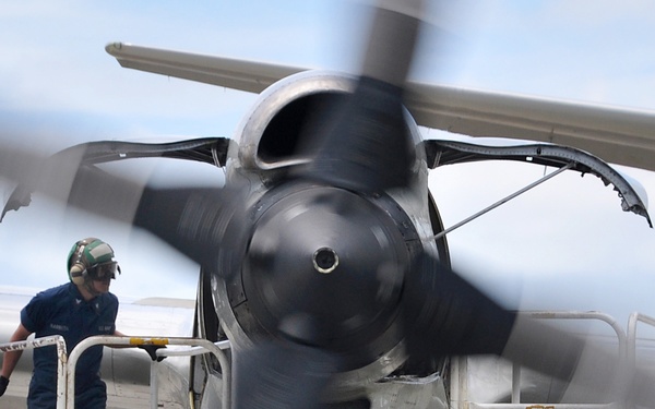 Petty Officer 3rd Class Alfred Barreta inspects the engine compartment of a P-3C Orion aircraft.