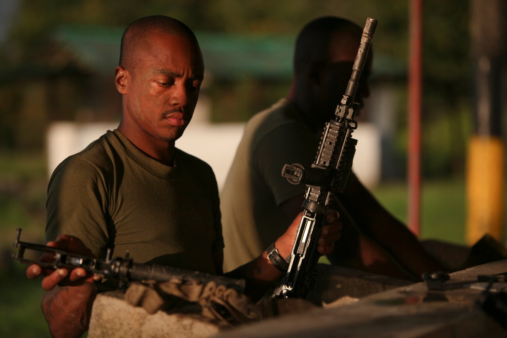 A U.S. Marine sergeant cleans his gear after a day of jungle warfare training.