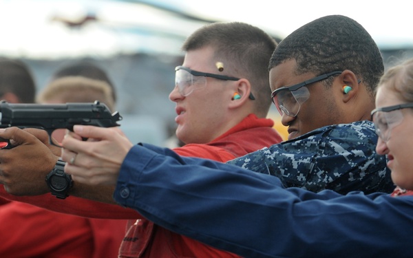 U.S. Navy sailors fire 9 mm Beretta pistols during a small arms shoot.