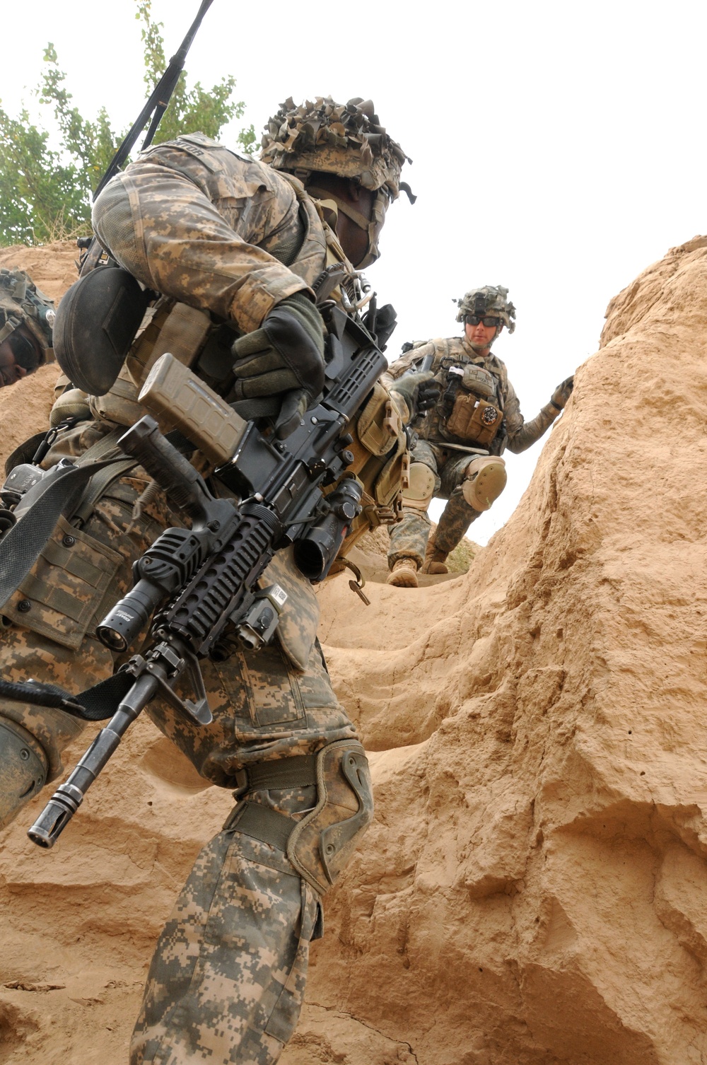 Cpl. Christopher Kuntor helps Spc. Charles Brooks into a riverbed during a presence patrol.