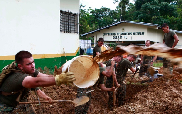 U.S. Marine Corps engineers dig a drainage pit at an engineering site.