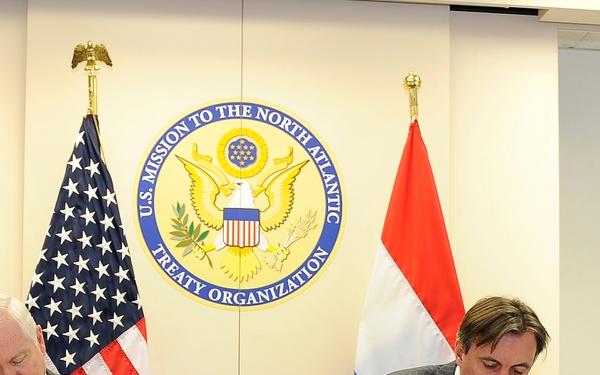 Secretary Gates and Minister for Defense of Luxembourg Jean-Marie Halsdorf sign an agreement.