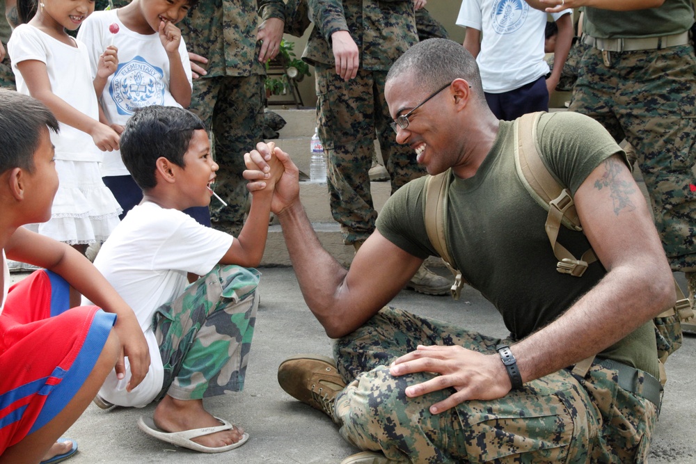 A U.S. Navy sailor entertains children at Calumpang Elementary School.