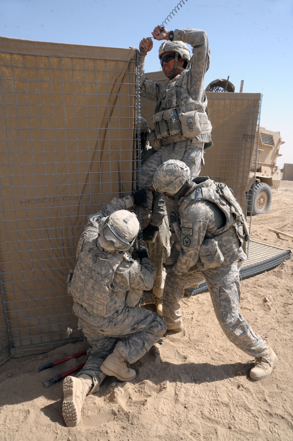 U.S. Army soldiers, continue a second day setting up HESCO barriers.