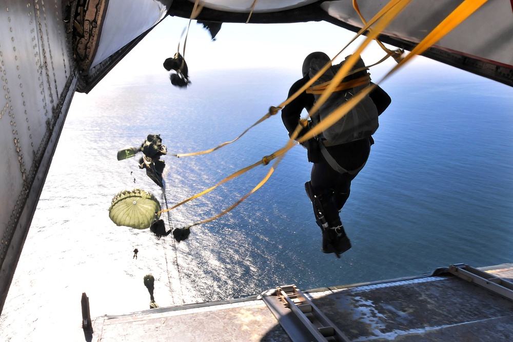 U.S. Navy Explosive Ordnance Disposal technicians perform a static line water drop.